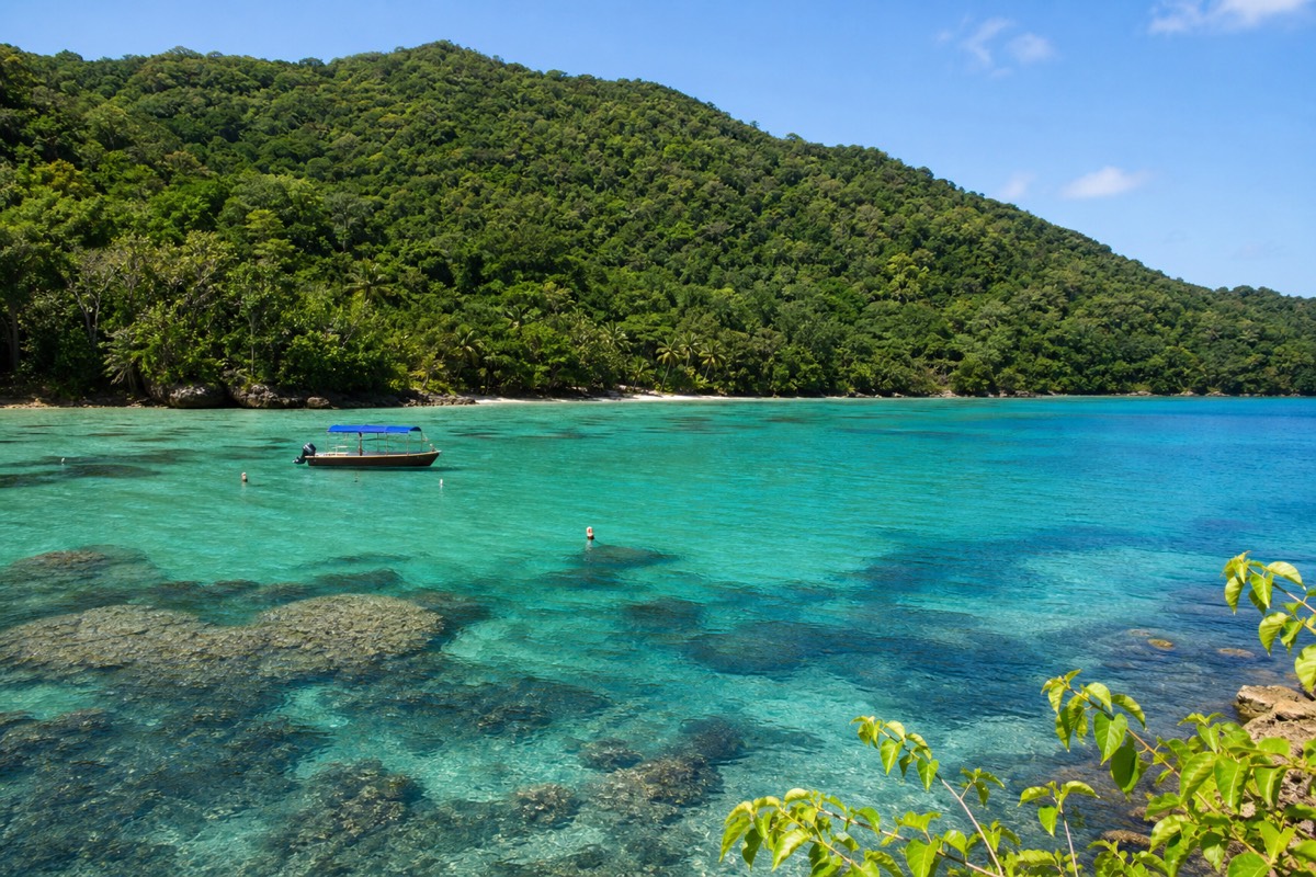 Clear turquoise water over coral heads inside the Belize Barrier Reef, the feature Costa Rica has no equivalent of