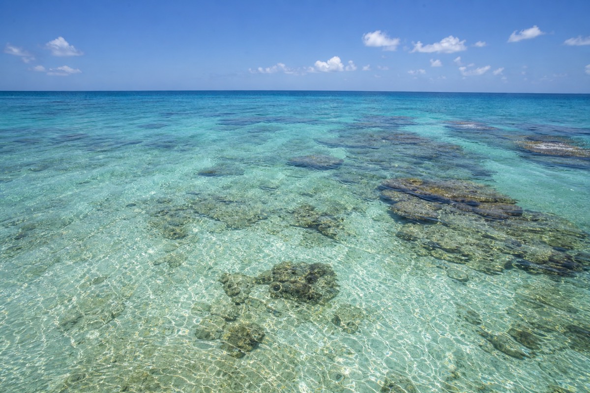 Flat calm turquoise water over the Belize Barrier Reef on a clear dry-season morning